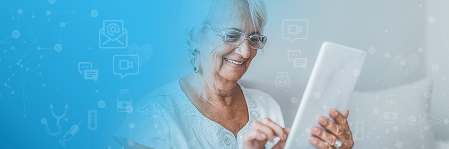 Elderly woman smiling while using a tablet.