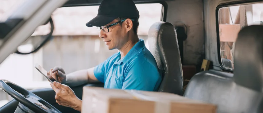 MDM で管理されたモバイルデバイスで配送を調整する配達ドライバー