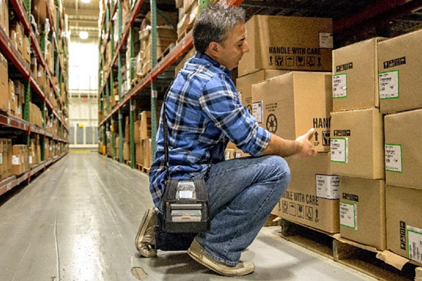 A device that is managed and secured by the SOTI ONE Platform helps a warehouse worker do his job efficiently