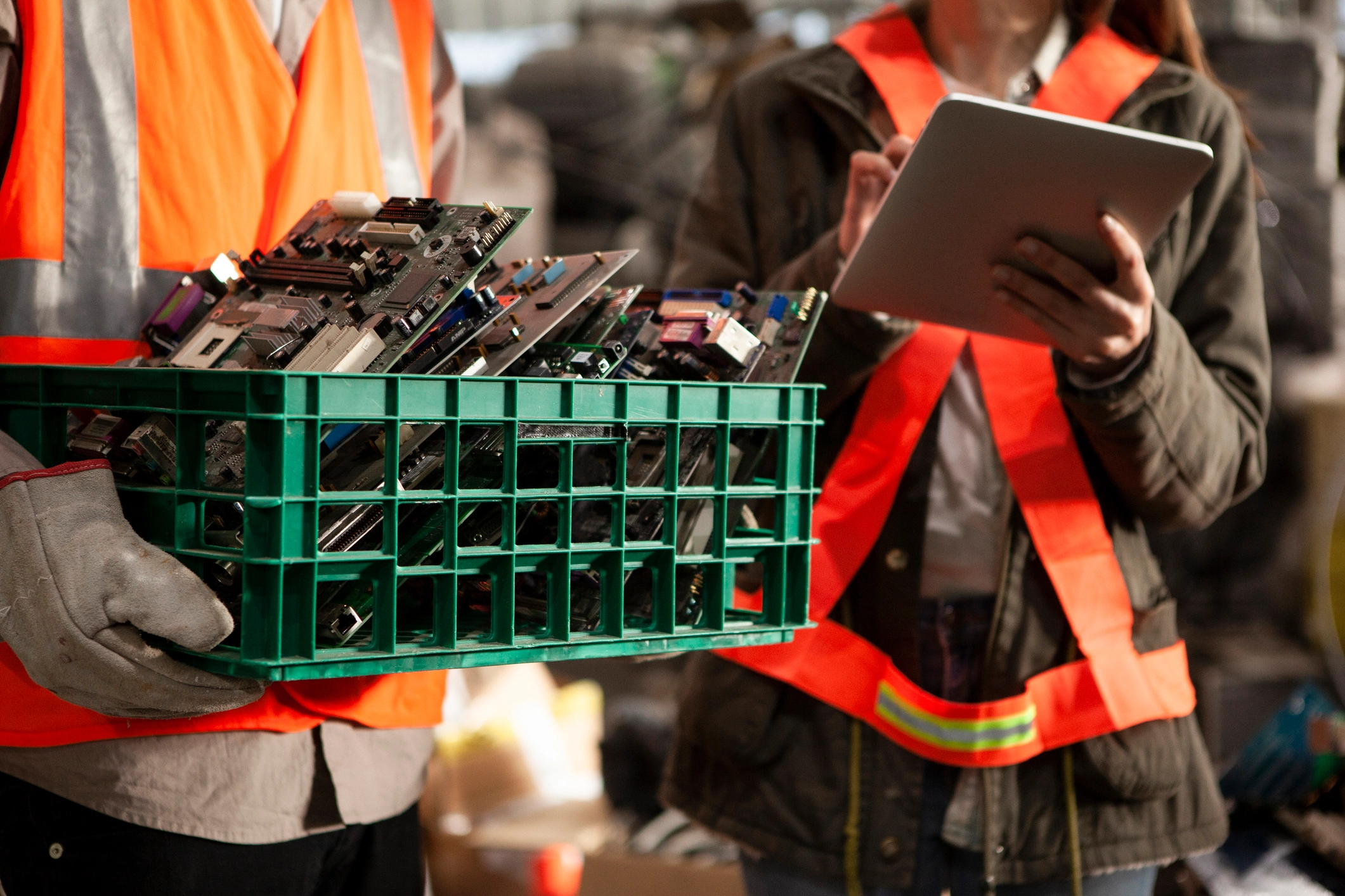 Two Securis Employees. One carries motherboards in a crate, while the other is keeping track on a tablet