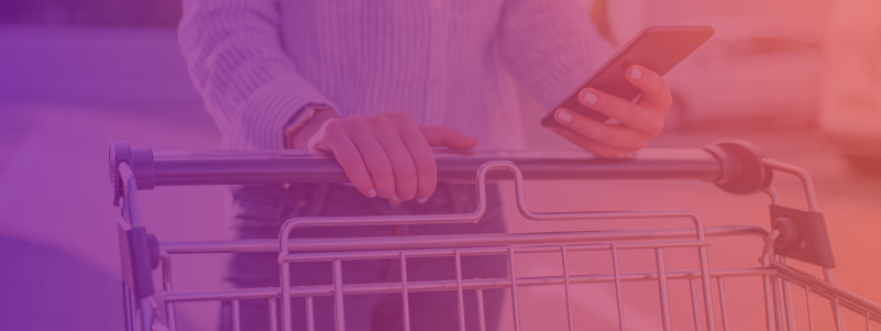 A man looking at his phone while grocery shopping